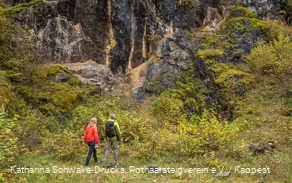 Zwei Wanderer vor einer Felswand